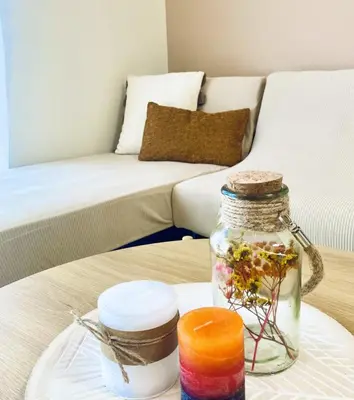 a table with a glass jar with flowers in it at AmaliZen, Steps From The Sea in Chania Town