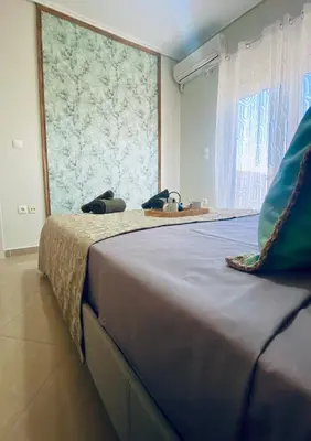 a large bed in a room with a large window at AmaliZen, Steps From The Sea in Chania Town