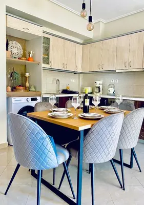 a kitchen with a table with chairs and wine glasses at AmaliZen, Steps From The Sea in Chania Town