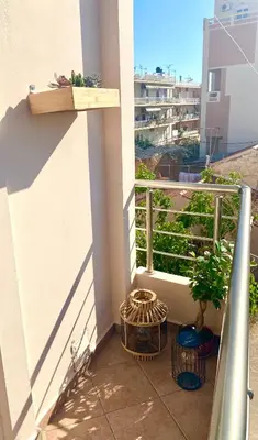 a balcony with two potted plants on a building at AmaliZen, Steps From The Sea in Chania Town
