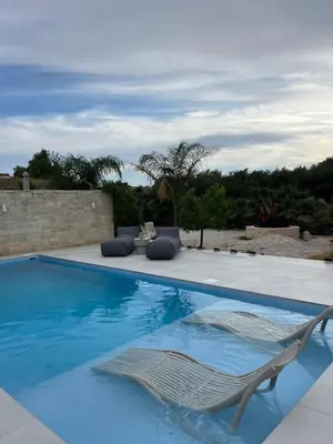 a swimming pool with a lounge chair at Amare suite 2 in Perivólia