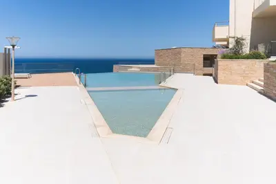 a swimming pool on the side of a building at Kymvari - Stunning sea view-elegant apt-infinity shared pool in Kalyves