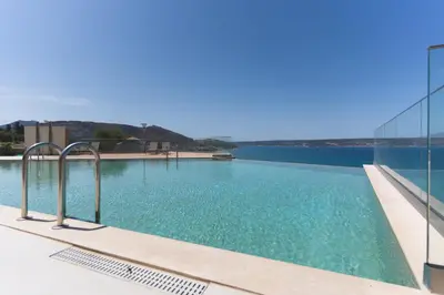 a swimming pool with a view of the water at Kymvari - Stunning sea view-elegant apt-infinity shared pool in Kalyves