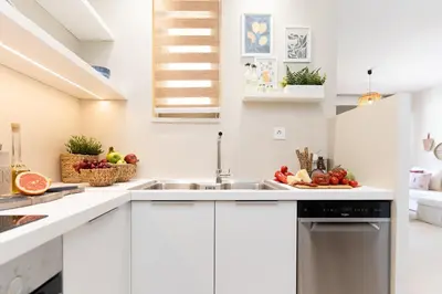 a kitchen with a sink and fruits on the counter at Kymvari - Stunning sea view-elegant apt-infinity shared pool in Kalyves