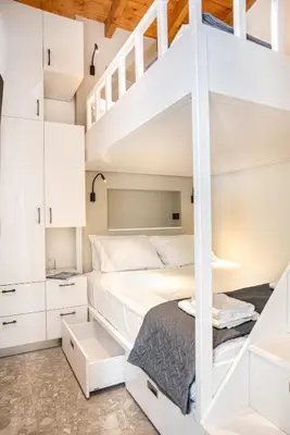 a bedroom with a bunk bed and white cabinets at The Nest in Chania Town