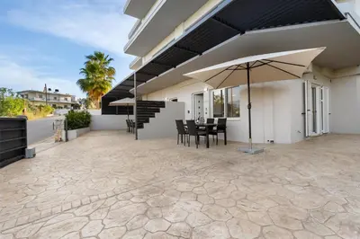 a patio with a table and an umbrella at Palea Luxury Living in Galatás
