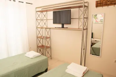 a room with two beds and a tv and a mirror at Souda Bay View Retreat in Souda