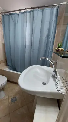 a bathroom with a sink and a shower curtain at Souda Bay View Retreat in Souda
