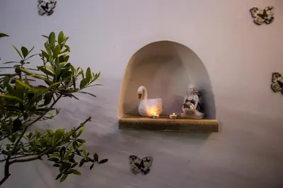a shelf with a cat and candles on a wall at Theodosia Heritage Residence in Kissamos