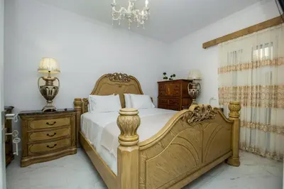 a bedroom with a large bed and a chandelier at Theodosia Heritage Residence in Kissamos
