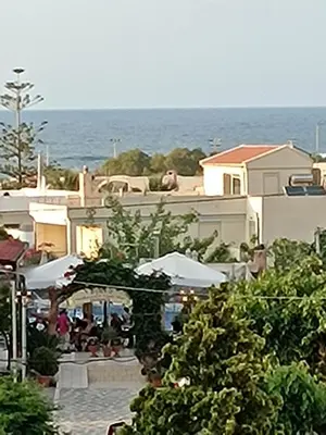 a group of people sitting on a patio near the ocean at Villa 