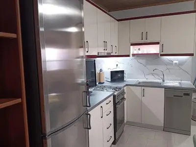 a kitchen with white cabinets and a stainless steel refrigerator at Villa 