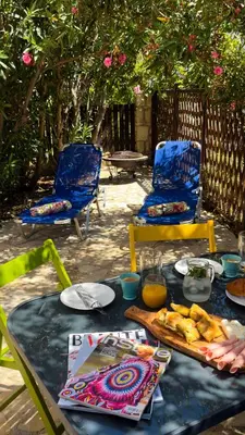 a table with plates of food and two chairs at SeawoodBreeze - Sea view and Quiet Escape in Tavronitis