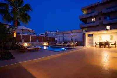 a backyard with a swimming pool at night at Be Crete - Villa Del Sol in Chania Town
