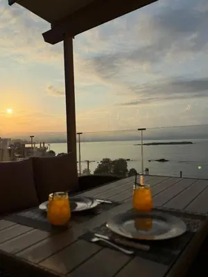 a table with two glasses of orange juice and a view of the ocean at Eteà Sea Penthouse-In the heart of chania in Chania Town