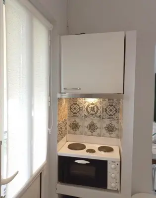 a kitchen with a stove and a white cabinet at Chania Town Center with Balcony by MPS in Chania Town
