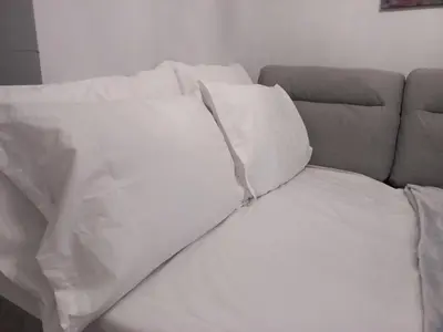 a couch covered in white sheets and pillows at Chania Town Center with Balcony by MPS in Chania Town
