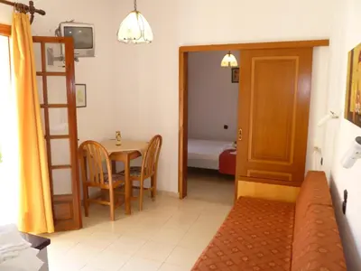 a living room with a table and a ladder and a room at Anniko in Stalos