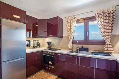 a kitchen with purple cabinets and a stainless steel refrigerator at Villa Rose in Chania Town