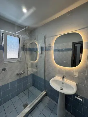 a bathroom with a sink and a shower with a mirror at Unique Apartment 3 in Chania Town