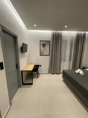 a bedroom with a desk and a bed and a table at Pnoé studio, Chania Center in Chania Town