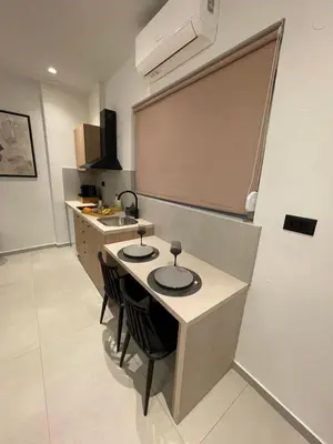 a kitchen with a counter with two chairs in it at Pnoé studio, Chania Center in Chania Town