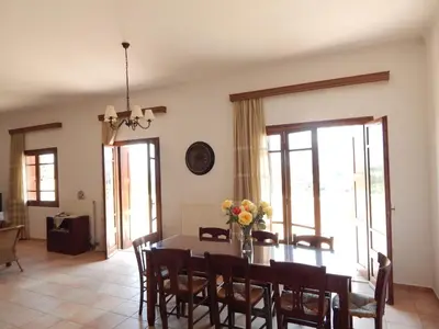 a dining room with a table with flowers on it at Kaina Villa in Vamos