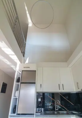 a kitchen with white cabinets and a mirror on the ceiling at Thalo Maison in Chania Town