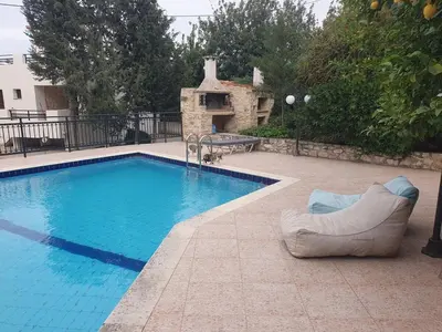 a swimming pool with a couch and a chair next to it at Villa Eudokia Terrace Views Pool in Douliana