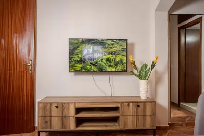 a living room with a wooden cabinet and a painting at Sellianos Apartment In Kalyves -BY APOKORONAS VILLAS in Kalyves