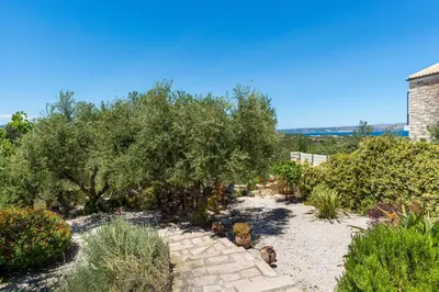 a garden with trees and a stone pathway at Villa Calista In Aspro -BY APOKORONAS VILLAS in Koprána