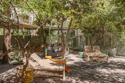 a patio with chairs and tables and trees at Eva's Apartment in Chania Town