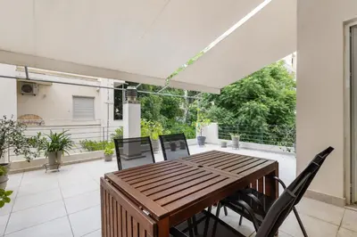 a patio with a wooden table and chairs on a balcony at Architects Oasis in Chania Town