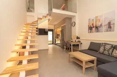 a living room with a spiral staircase in a house at Ikaros City Loft in Chania Town