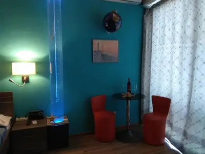 a room with two red chairs and a table at Blue Studios in Chania Town