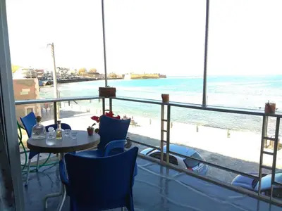 a room with a table and a view of the ocean at Blue Studios in Chania Town