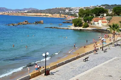 a group of people swimming in the water on a beach at Blue Studios in Chania Town