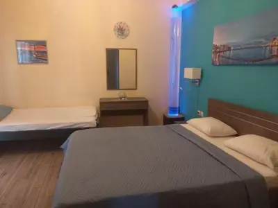 a room with two beds and a mirror at Blue Studios in Chania Town