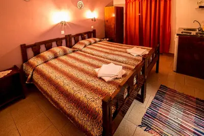a large bed in a bedroom with a red curtain at Savas Rooms in Palaiochóra