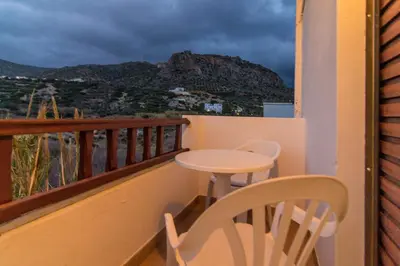 a balcony with a table and a chair and a view at Savas Rooms in Palaiochóra