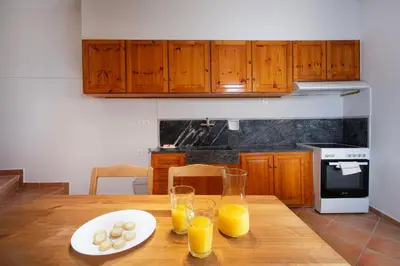 a kitchen with a wooden table with two glasses of orange juice at Artemis House in Chania Town