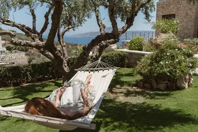 a woman laying in a hammock in a garden at Villa Niolos I in Marathi
