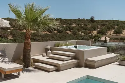 a patio with a hot tub and a palm tree at Villa Niolos I in Marathi