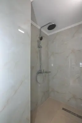 a shower with a glass door in a bathroom at Liastera Luxury Apartments in Áyios Fótios
