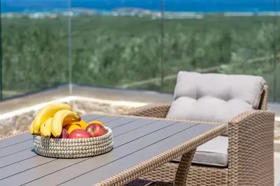 a bowl of fruit on a table on a patio at Liastera Luxury Apartments in Áyios Fótios