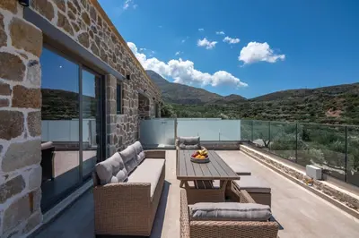 a patio with a table and chairs on a balcony at Liastera Luxury Apartments in Áyios Fótios