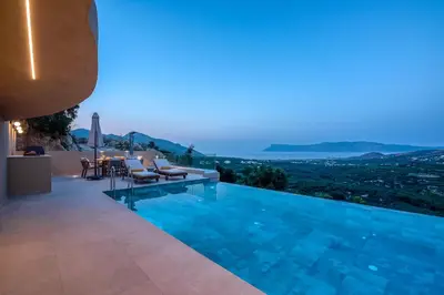 a villa with a swimming pool at night at Villa Tierra in Kissamos
