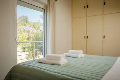 a bedroom with two towels on a bed with a window at Mantarini House in Chania Town
