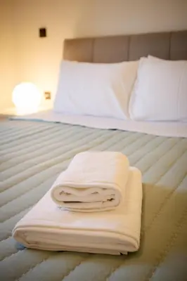 two towels are stacked on top of a bed at Mantarini House in Chania Town