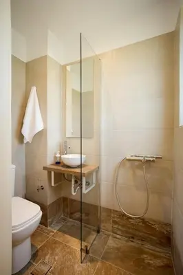 a bathroom with a shower and a toilet and a sink at Mantarini House in Chania Town